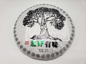 A compressed Pu'er tea cake with a graphic of a tree on it, indicating it is an 80-Year-Old Wild Tree Pu'er Tea from Yunnan, China.