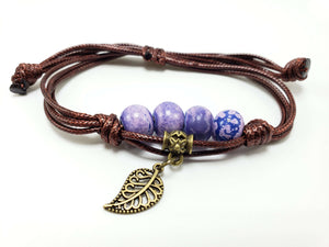 Purple bead bracelet with leaf charm on brown cord