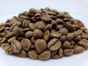 A pile of whole bean coffee in a light to medium roast.