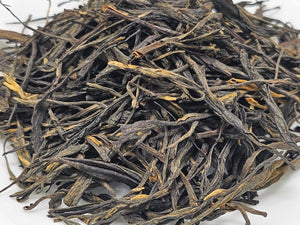 Pine Needle black loose-leaf tea with long, twisted leaves.